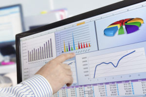 Man analyzing financial data and charts on computer screen